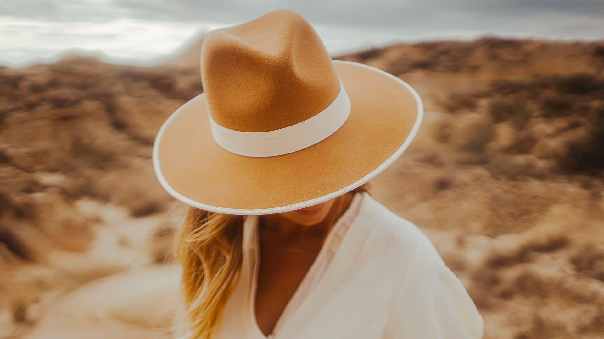 Chapeau en feutre beige et blanc porté avec une chemise blanche
