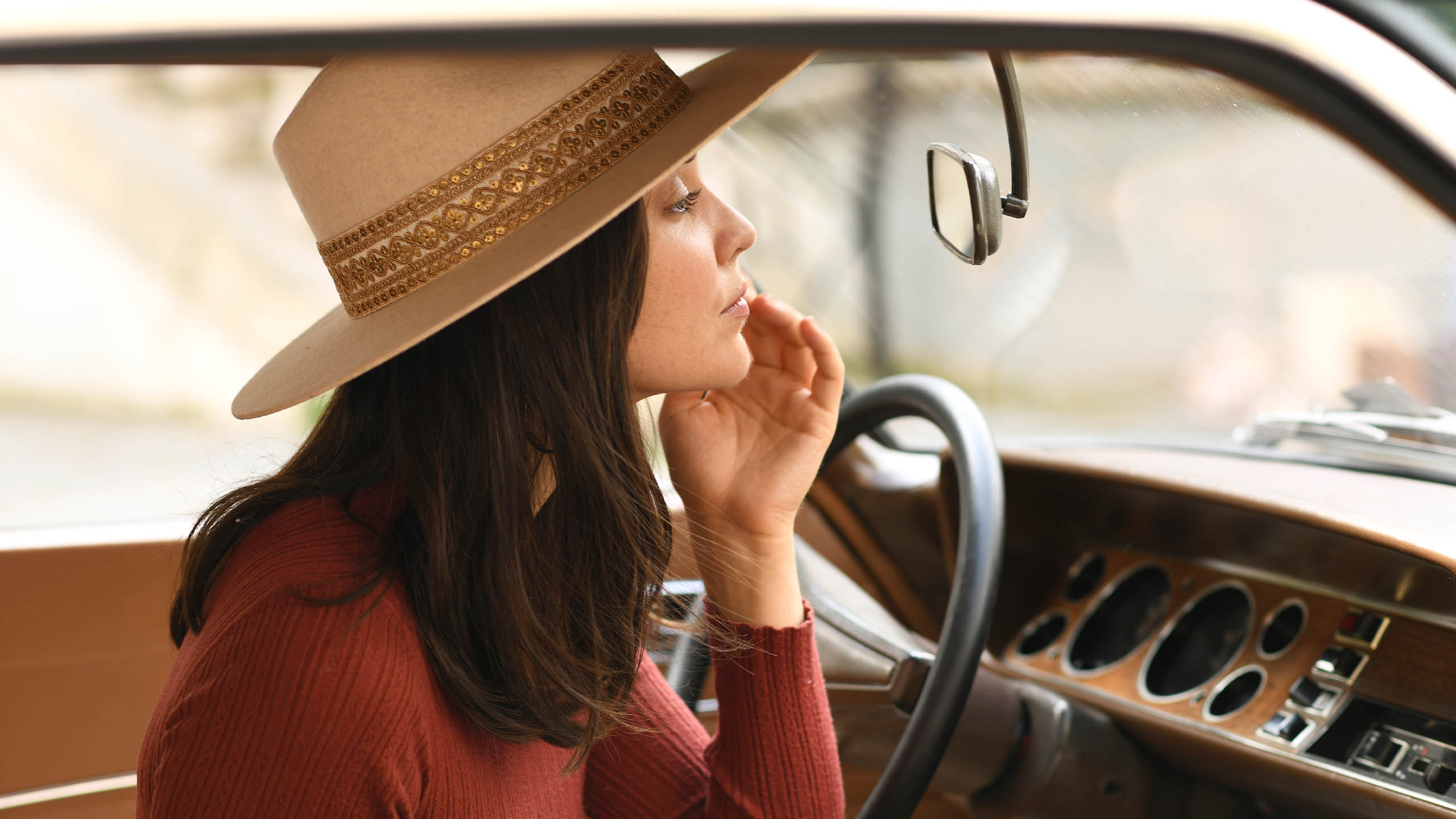 femme se maquille dans voiture retro