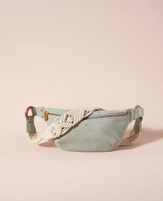 Photographie studio d'un sac banane en veau velours bleu et de sa bandoulière en coton tressé