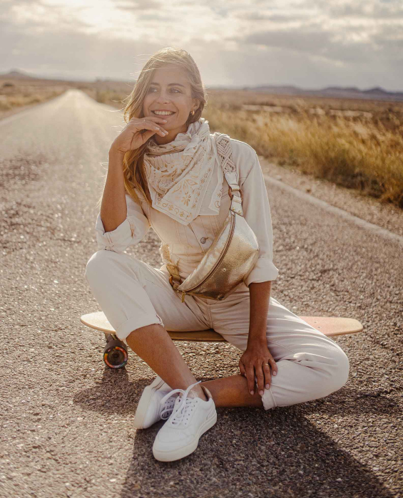 Femme très heureuse portant un sac banane en cuir doré