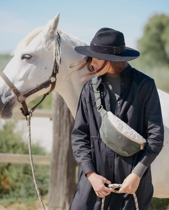 Femme portant un sac banane devant un cheval