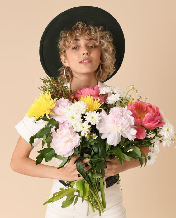femme avec un bouquet de fleurs pivoines